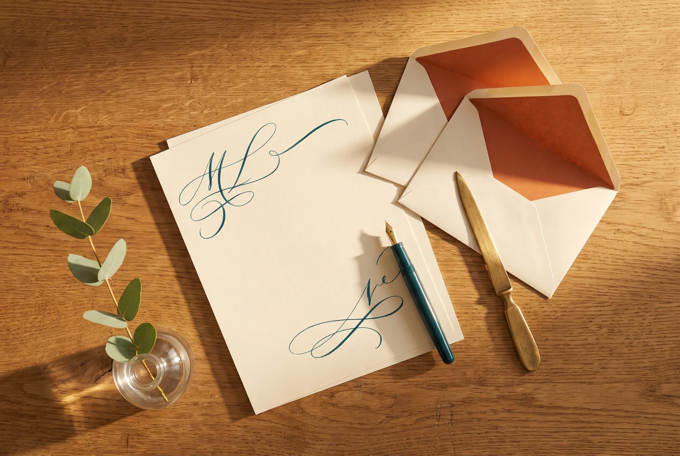 Warm stationery with a fountain pen and envelopes on an oak desk
